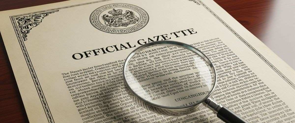 Official Gazette Notification Document Magnifying glass over an official gazette notification document with a seal.
